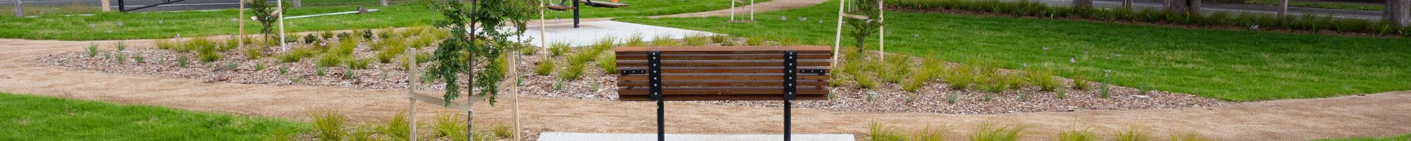 Overlooking a park bench in the middle of a grassy park