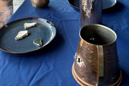 Artwork from Settlement on display on blue cloth.